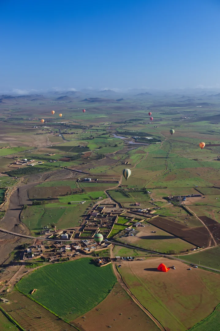 Patchwork van akkers, palmbomen en kleine dorpjes gezien vanuit een luchtballon